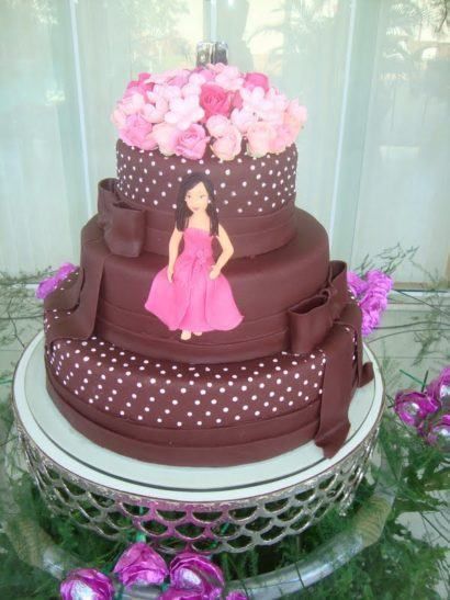 Bolo com três andares na cor marrom com decoração em rosa