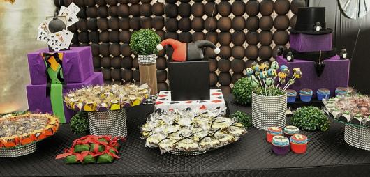 Mesa de doces decorada com chapéu da Arlequina e roupa do Coringa