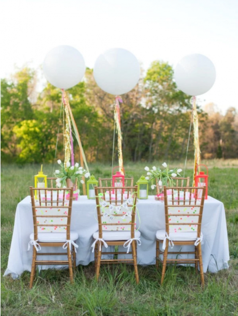 Mesa de festa de convidados decorada com bexigas brancas