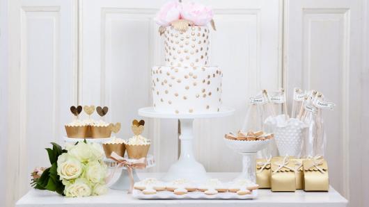 Mesa de doces e bolo nas cores branco e dourada