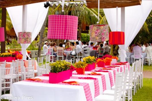 Mesa com toalhas rosas e brancas.