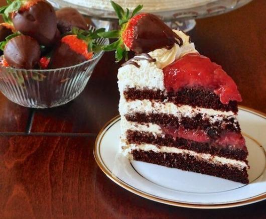 Pedaço de bolo floresta negra com morangos de quatro camadas.