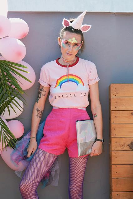 Camiseta de arco-íris, shorts rosa e tiara de unicórnio.