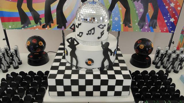 Bolo de discoteca, com base quadriculada e camada superior de globo prateado.