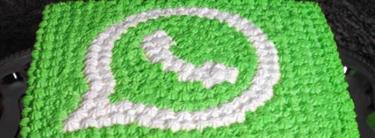 Bolo com cobertura de chantilli e símbolo do whatsapp.