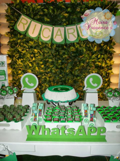 Mesa com símbolos do whatsapp e comidas em embalagens verdes.