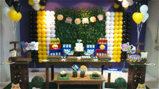 Painel verde com balões amarelos e brancos. Mesa principal com emoticons.