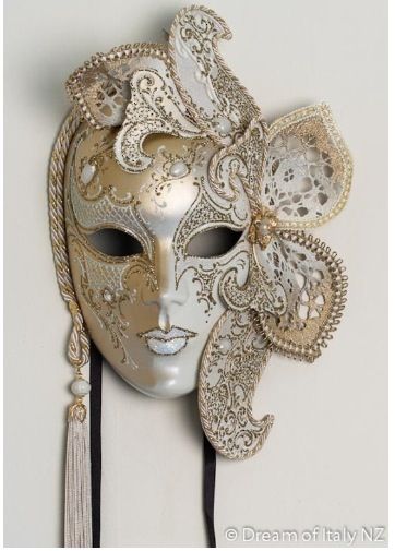 máscara de Veneza dourada com flores ao lado