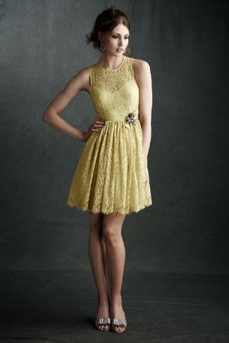 Modelo usa vestido de renda amarelo, acinturado com sapato na cor prata.