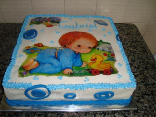 bolo de batizado azul e branco com papel de arroz de uma criança brincando