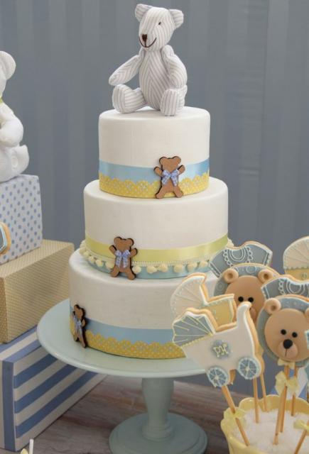 bolo de três andares branco com fitas e ursinhos encima e ao lado