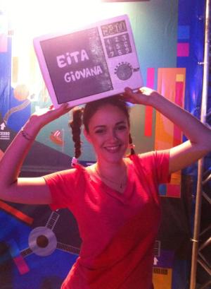 garota segurando plaquinha escrita Eita Giovana