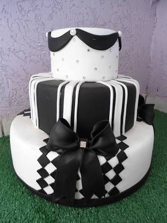 bolo com dois andares branco com detalhes em preto, e um andar preto com detalhes em branco. Tem um laço também