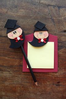 lápis e bloquinho com bonequinho de formanda