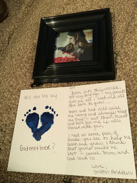 Foto de mulher com bebê e cartão com o desenho dos pés do bebê.
