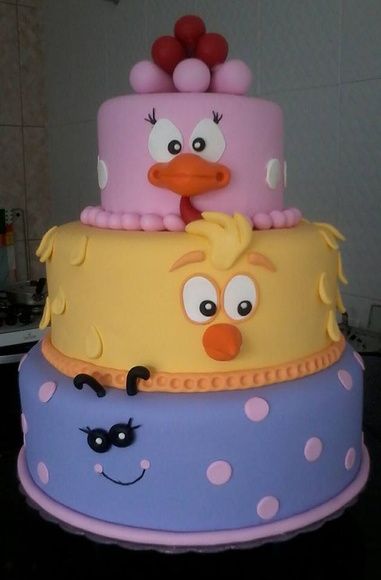 Bolo com um andar azul, um amarelo e um rosa.