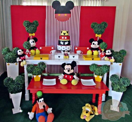 Mesa branca, aparador vermelho e vasos brancos.