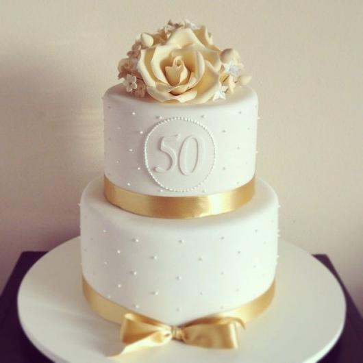 Bolo branco de 2 andares com detalhes de fita dourada e flores de açucar