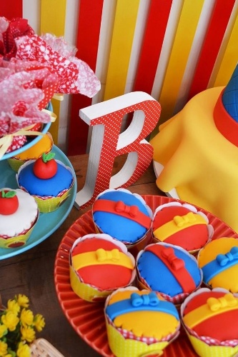 Cupcake Branca de Neve cute decorado com lacinhos amarelos e vermelhos