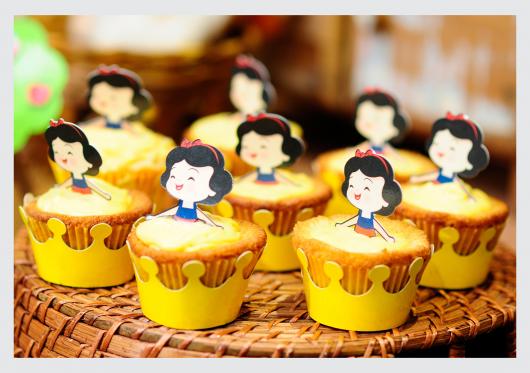 Cupcake Branca de Neve com wrapper amarelo e topper da Branca de Neve