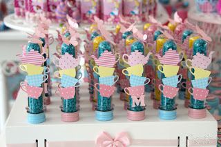 Tubetes de tampa rosa e azul, com confete e enfeite de xícara.