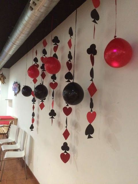 Decoração com balões e naipes em vermelho e preto.