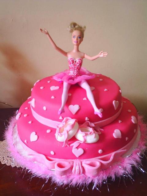 Bolo da Barbie com predominância da cor pink e boneca no topo