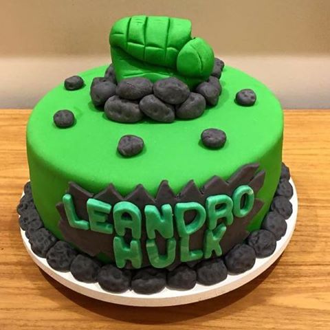 Bolo do Hulk decorado com nome do aniversariante e topo de punho verde saindo de rochas