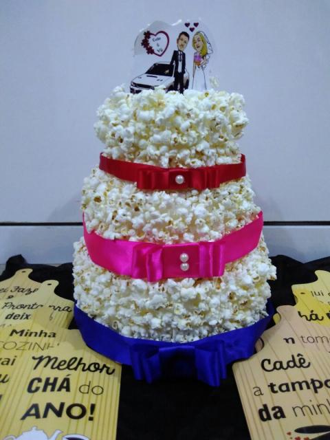 Bolo fake de pipoca com laço azul, rosa e vermelho