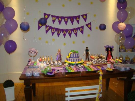 Festa Rapunzel simples decorada com mesa rústica balões e varal de bandeirinhas