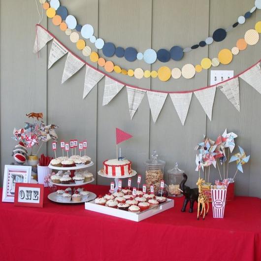 Mesversário decoração do Circo com varal de bandeirinhas e toalha de mesa improvisada vermelha
