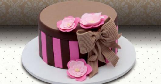 Bolo de Aniversário Feminino decorado com laço e flores de pasta americana