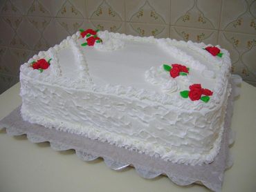 Bolo Dia das Mães decorado com chantilly branco e rosinhas vermelhas