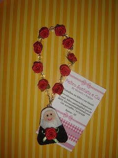 Tercinho de flores vermelhas com santinha na ponta.