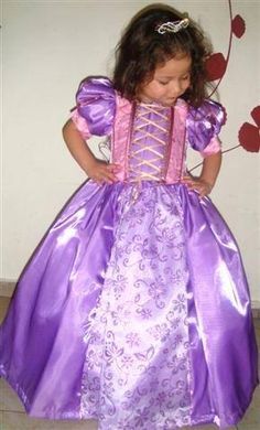Criança com as mãozinhas na cintura vestida de rpunzel.