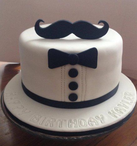 bolo branco com decoração de bigode e gravata borboleta em preto