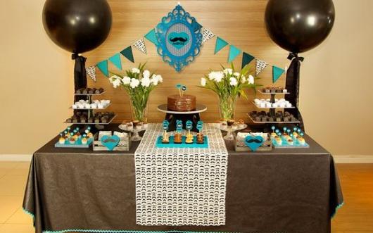 mesa de doces com tons de azul e preto com decoração de bigode