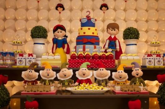 parede de balões branco atrás de mesa decorada com tema da Branca de Neve