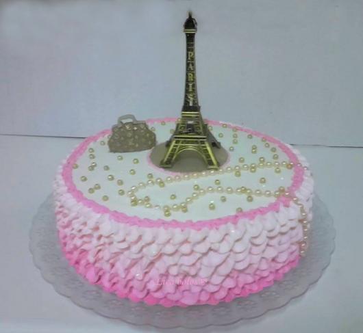 bolo com chantilly ao redor e Torre Eiffel no topo com pérolas
