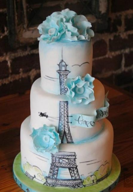 bolo branco com detalhes em azul e torre Eiffel desenhada 