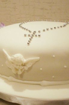 bolo branco com crucifixo em prateado no topo