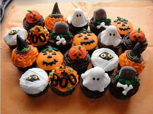 Cupcakes decorados com abóboras, fantasmas e chapéus de bruxa.