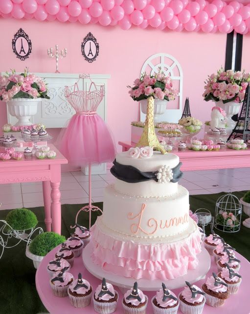 Fundo rosa claro, com mesas, flores e itens decorativos rosas.