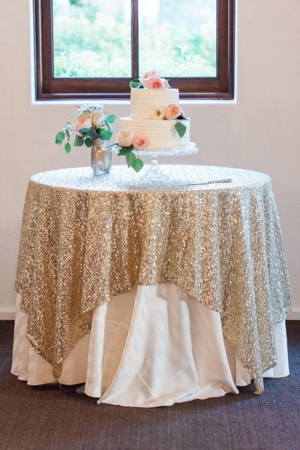 mesa com bolo com toalha dourada