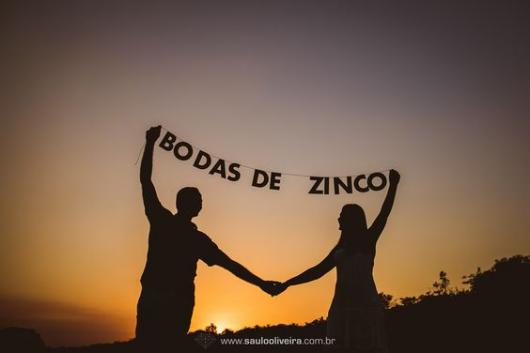 Casal segurando letras que formam a frase " bodas de zinco".