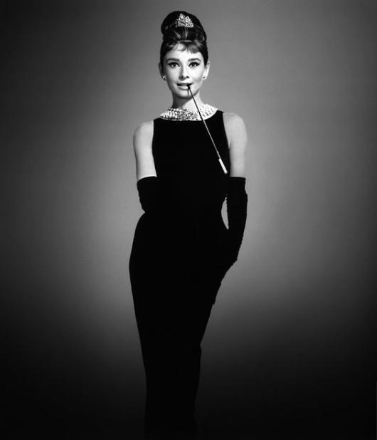 Audrey Hepburn com vestido e luvas pretas.