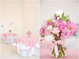 Decoração com mesas com toalhas rosas e centro de mesa com arranjo de flores
