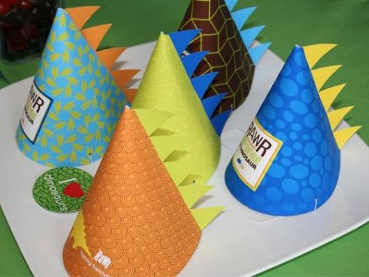 Chapéu de aniversário com enfeite que imita as costas de um dinossauro.