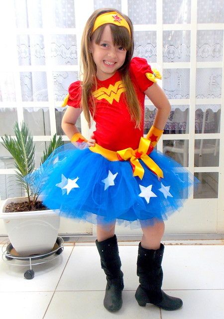 Menina vestida de Mulher Maravilh, com saia azul e camiseta vermelha.
