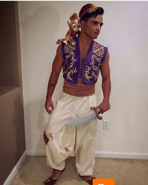 Homem fantasiado de Aladin, com calça branca e colete azul.